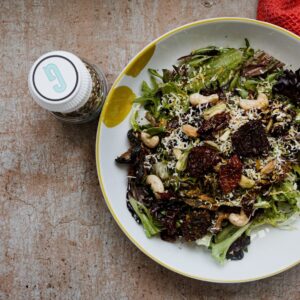 a plate of salad and a drink on a table