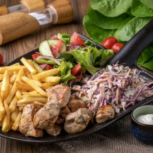 a plate of food with french fries, salad, lettuce, tomatoes and