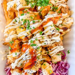 Loaded fries with chicken, coleslaw, and sauce