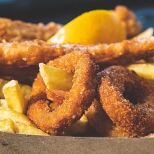 A basket filled with fried food and a lemon wedge