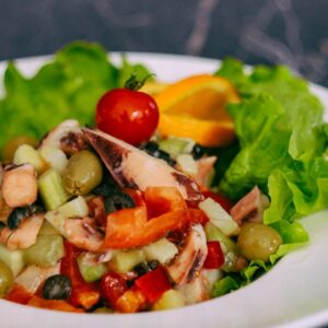 a white plate topped with a salad covered in fruit
